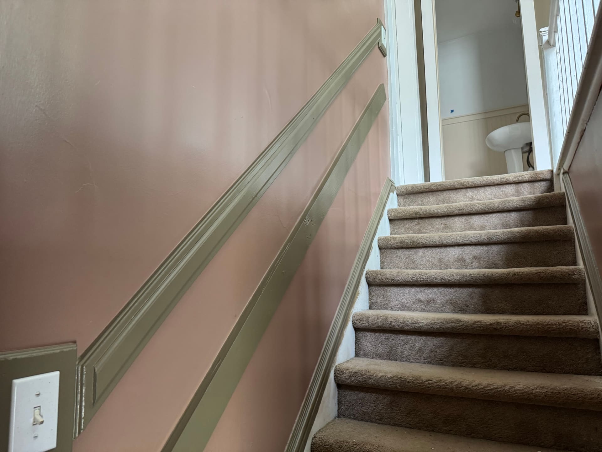 Stairwell looking down toward the bottom before repaint, original wall color and trim