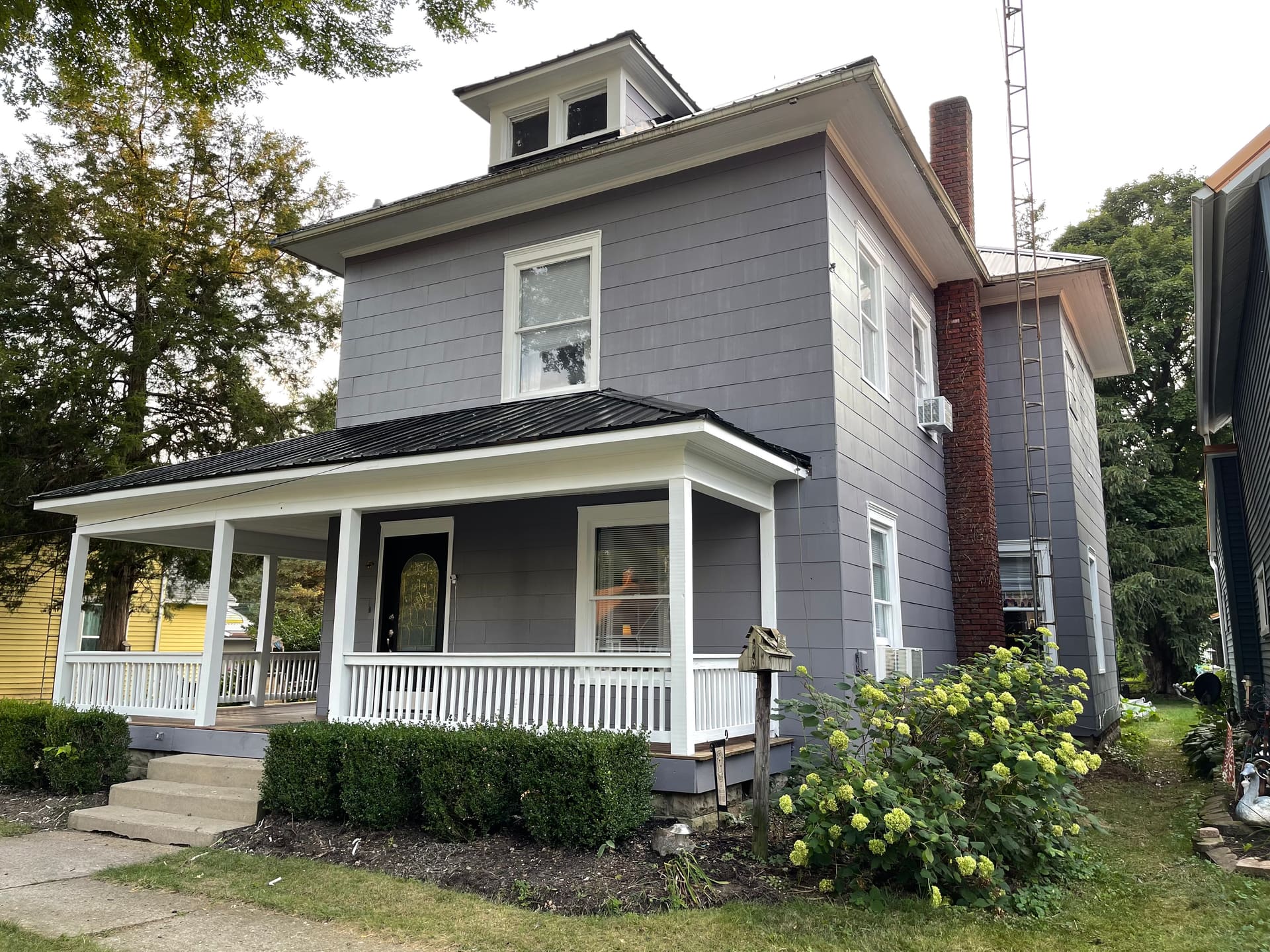 Side view of the same two-story gray-painted home