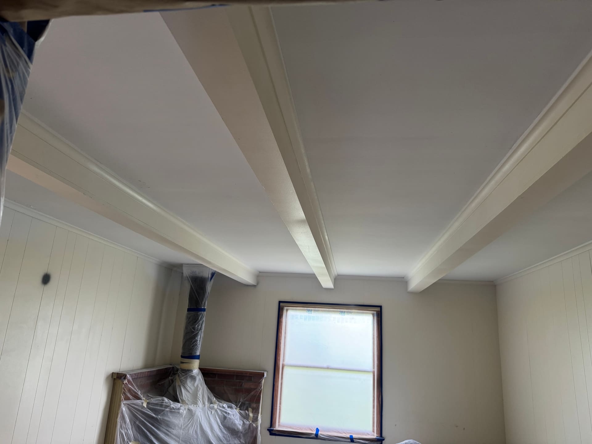 Interior ceiling masked off with plastic sheeting and tape ahead of an interior repaint